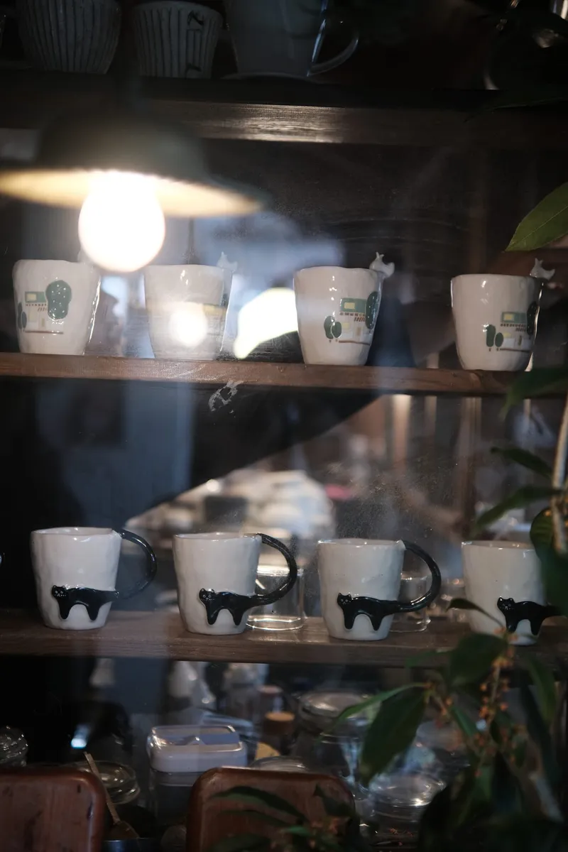 Black Cat mug on a wooden shelf among other studio mugs