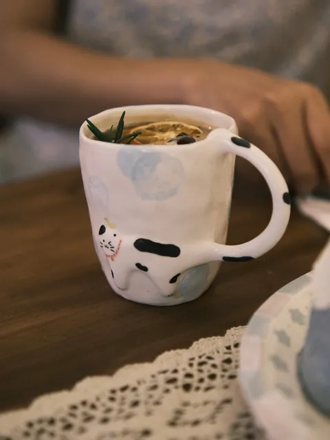 Cow cat mug with tea on a wooden table