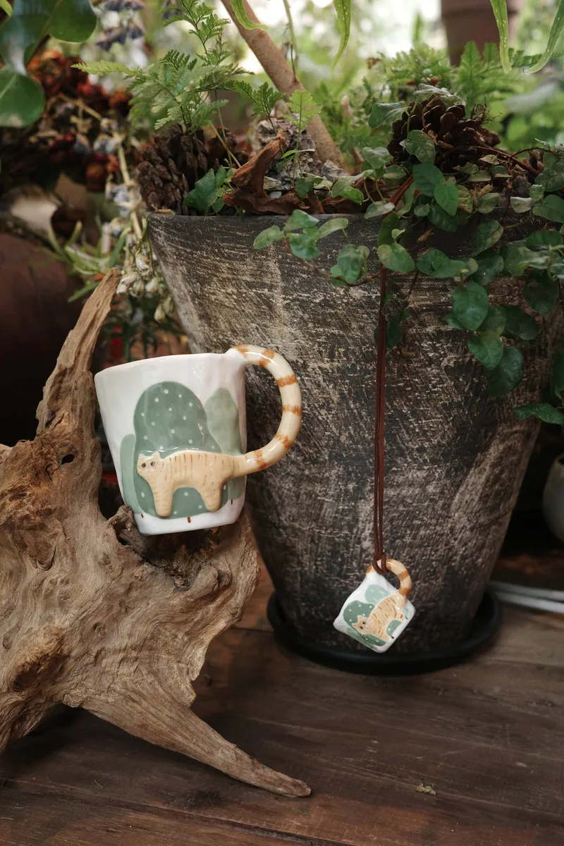 Orange cat mug and a mini mug on driftwood