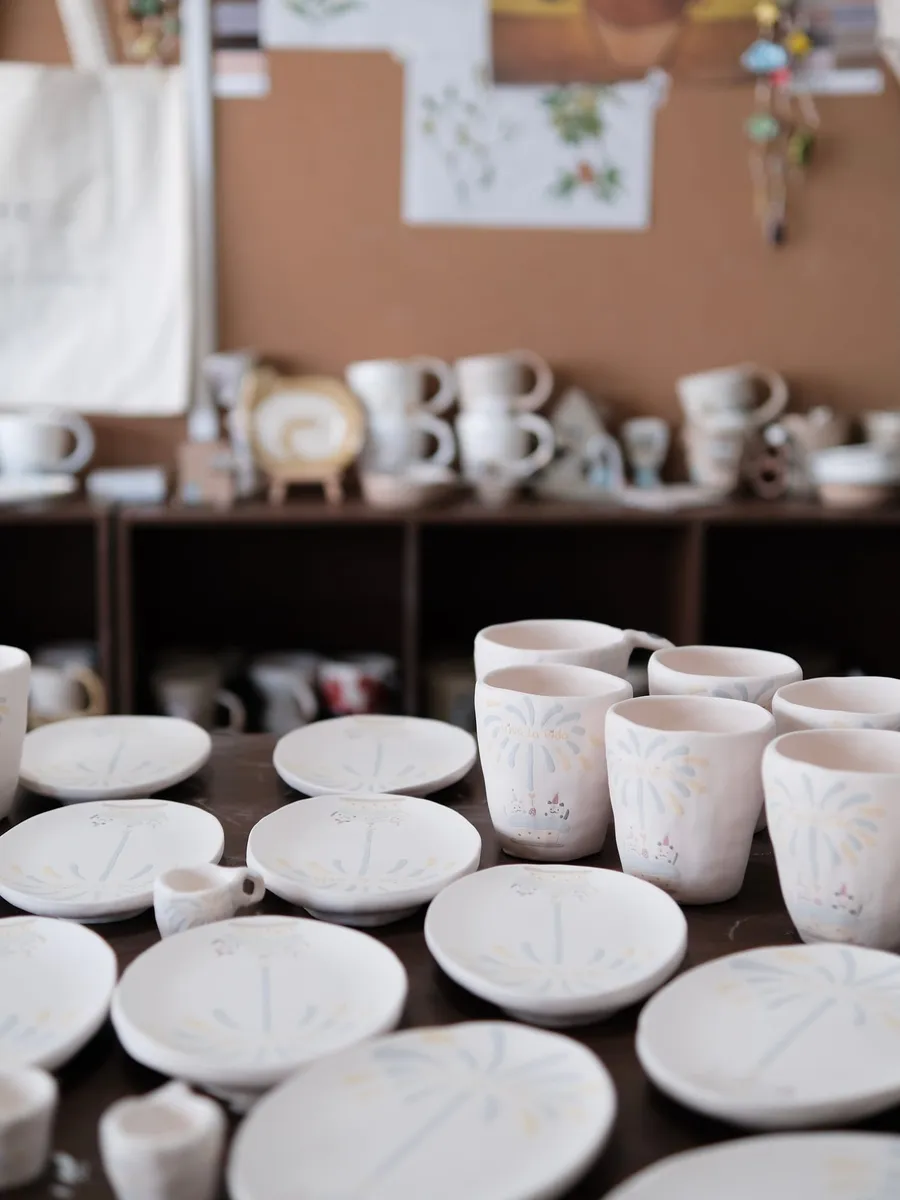 Shelves of bisque plates and mugs in the studio